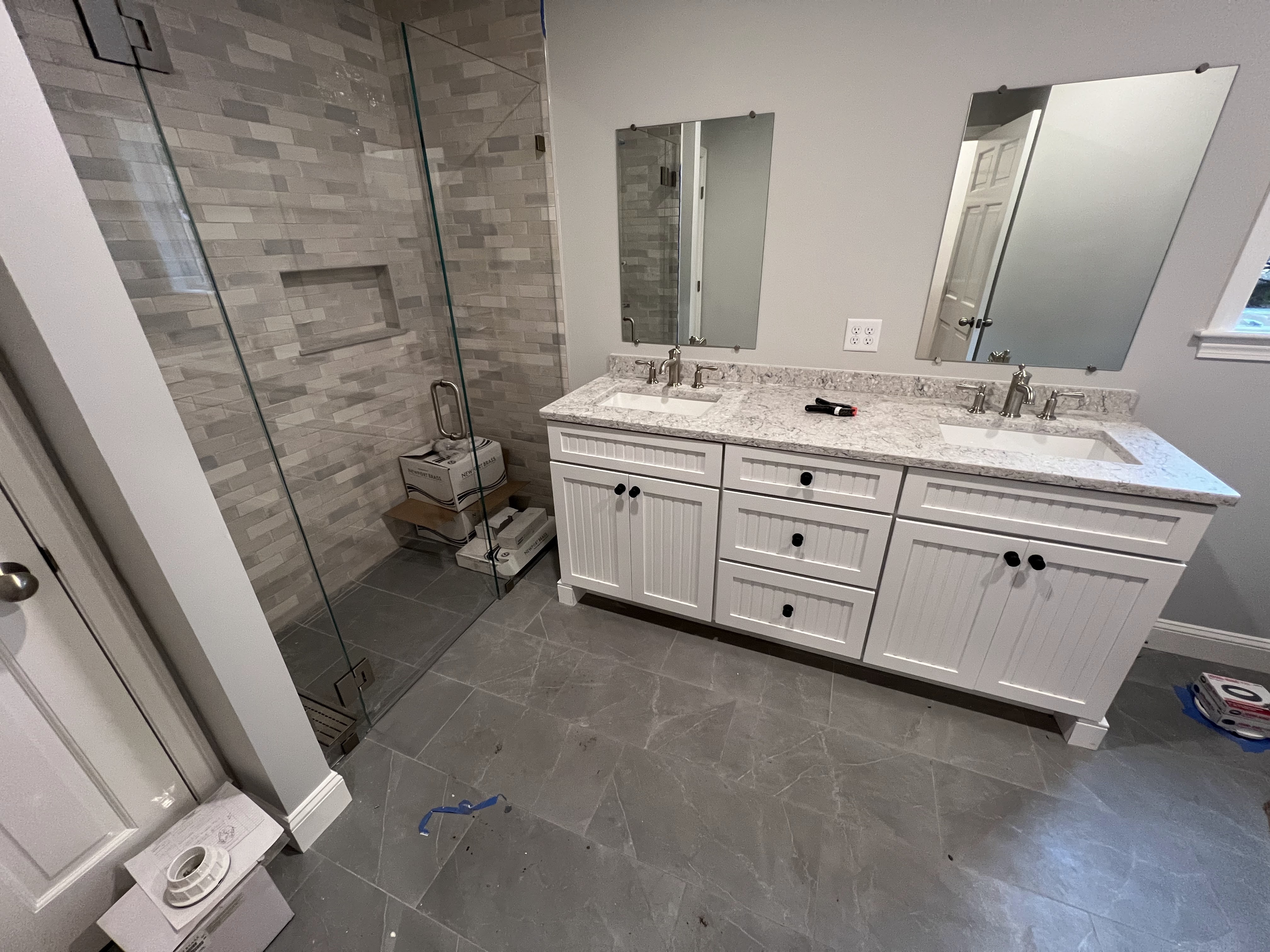 Bathroom vanity, tiled shower and glass enclosure.