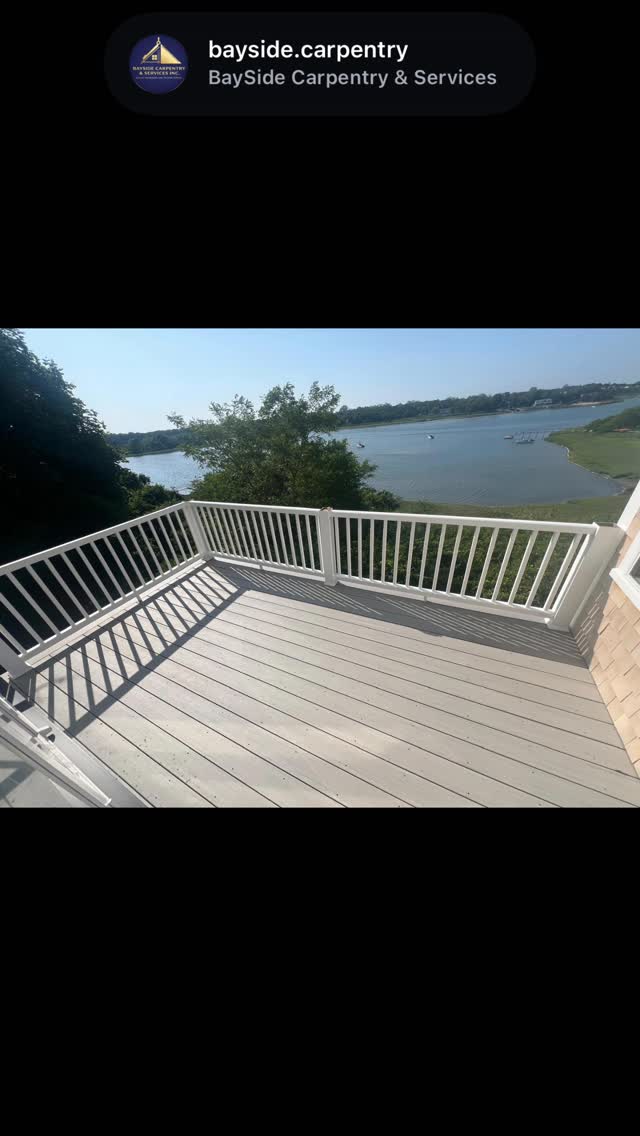 Decking and white railings overlooking the water.
